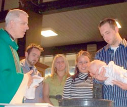 Fr. Mark Brewer Baptises a Child